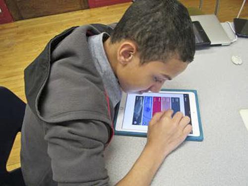 Misael working on his iPad with Google Classroom