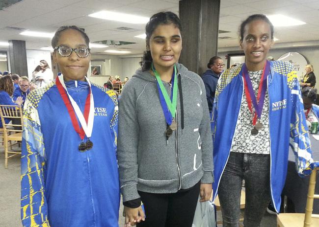 3 girls smiling with their medals