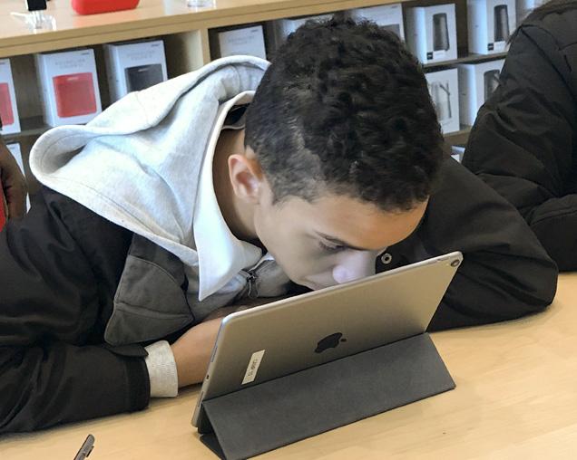 Low vision students looking closely at his ipad during the class