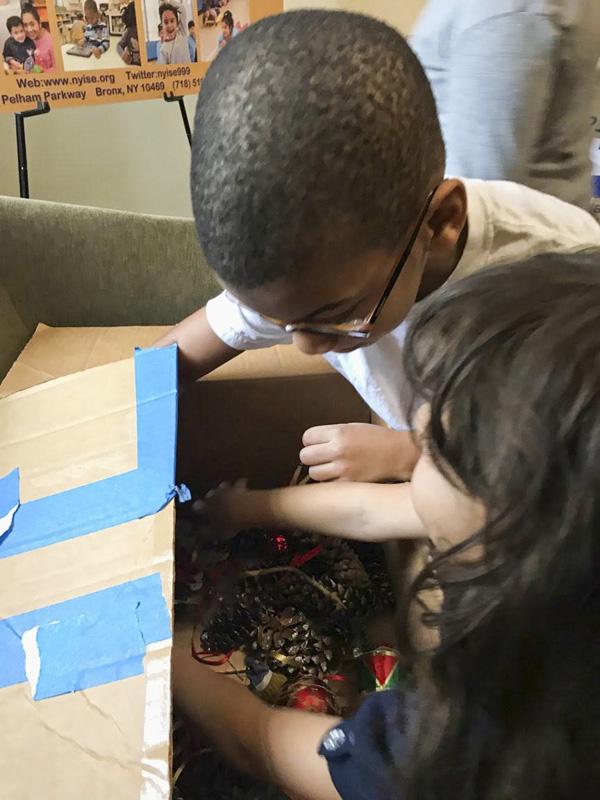 Students looking for more ornaments in a storage box