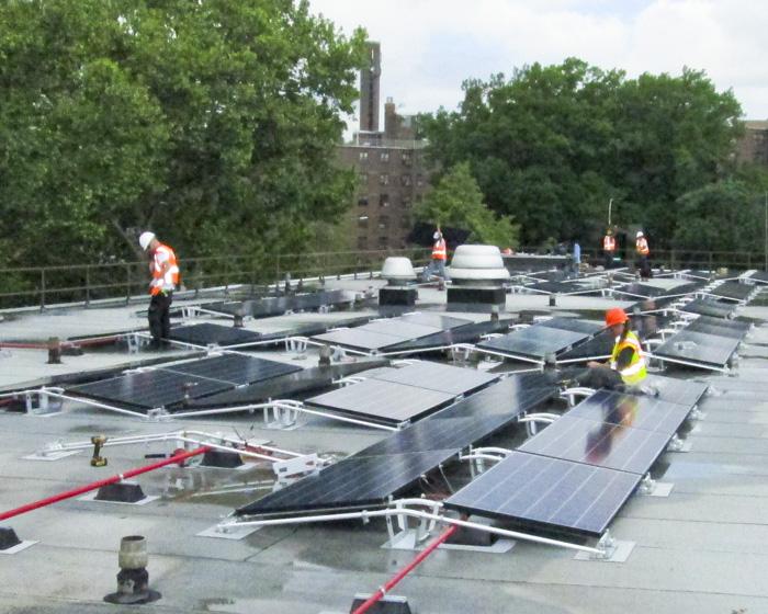 Workers on the Frampton Hall roof working on installation of panels