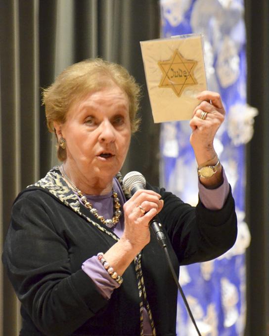 Ms. Kazan holding a yellow Jewish star witht the word JUDE. 