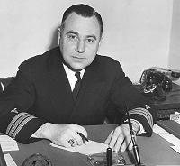 Merle Frampton at his desk dressed in Naval Uniform